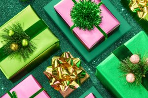 Festive gift boxes in green and pink with gold bows and pine decorations