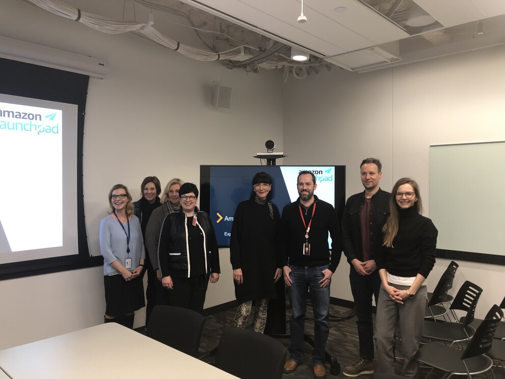 Ein Gruppenfoto der Launchpad-Session-Teilnehmer in einem Besprechungsraum (links und im Hintergrund sind Tafeln zu sehen).