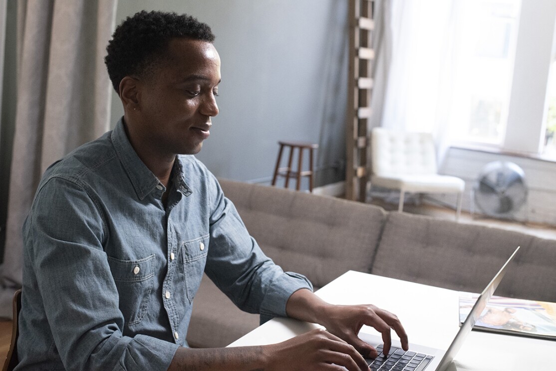 Amazon training program attendee sits at his desk and types on a laptop.