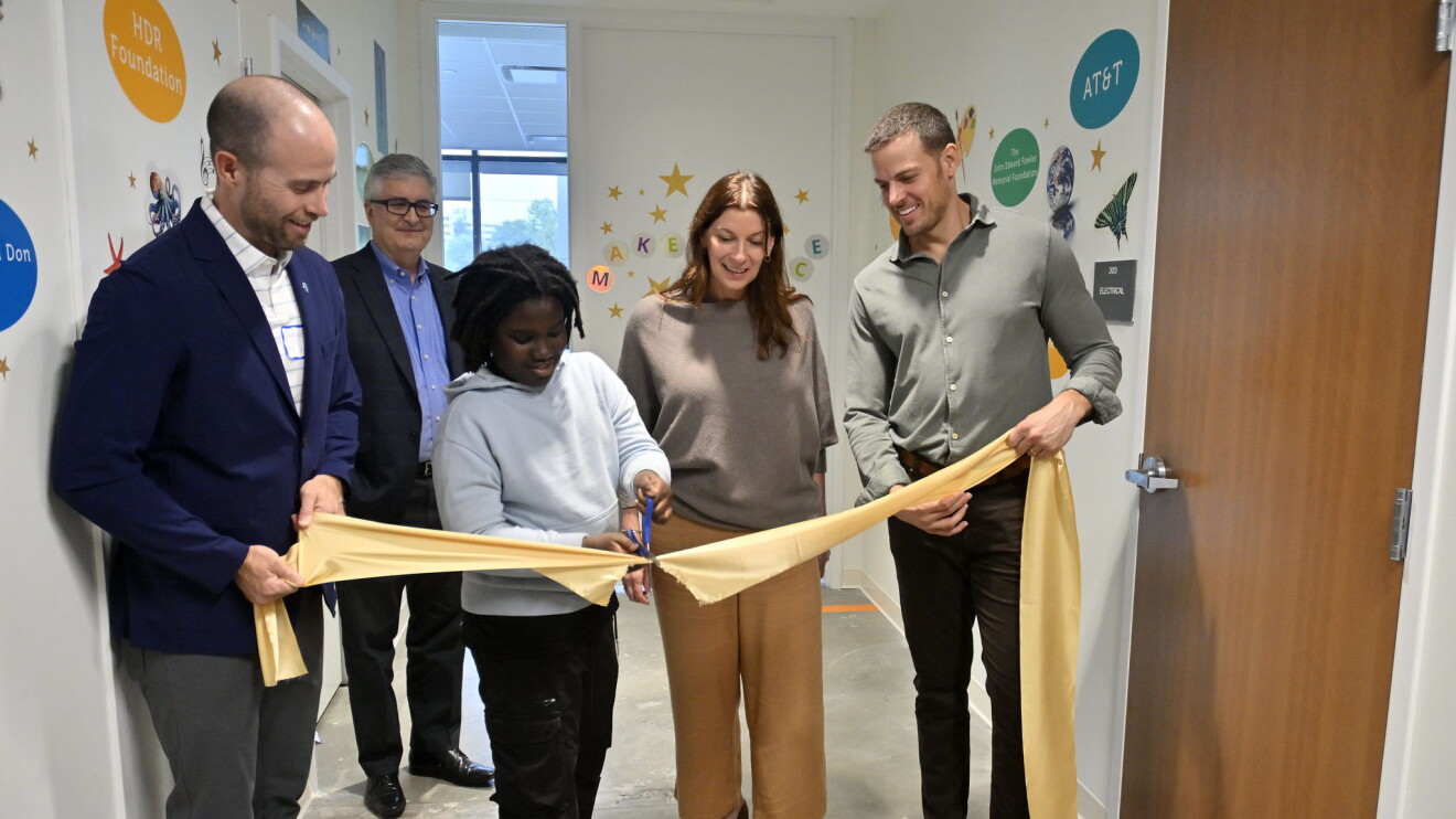 child cutting a rubbon at a Makerspace ribbon cutting in Arlington, VA