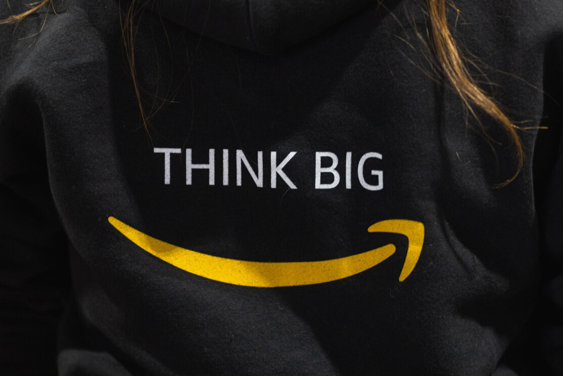 Napis "Think Big" na czarnej koszuli, pod spodem logo Amazon