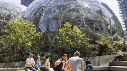 图像的人坐在外面草地上的球体。