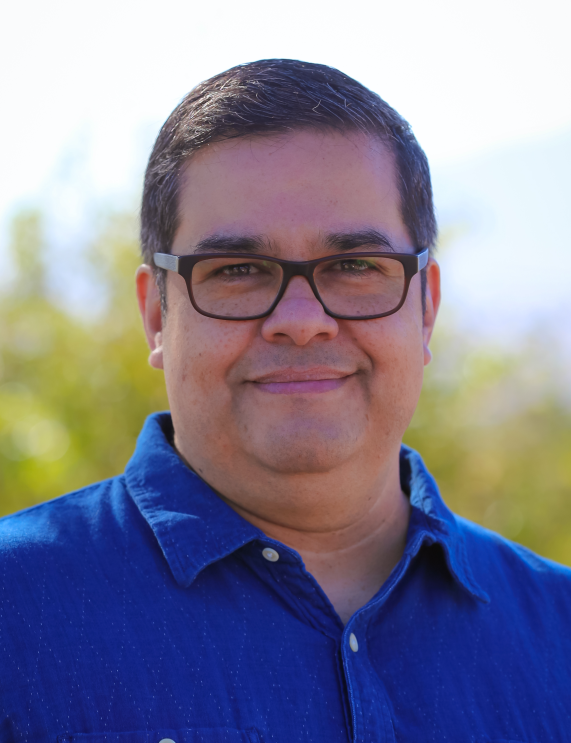 An image of a man smiling for a headshot photo.