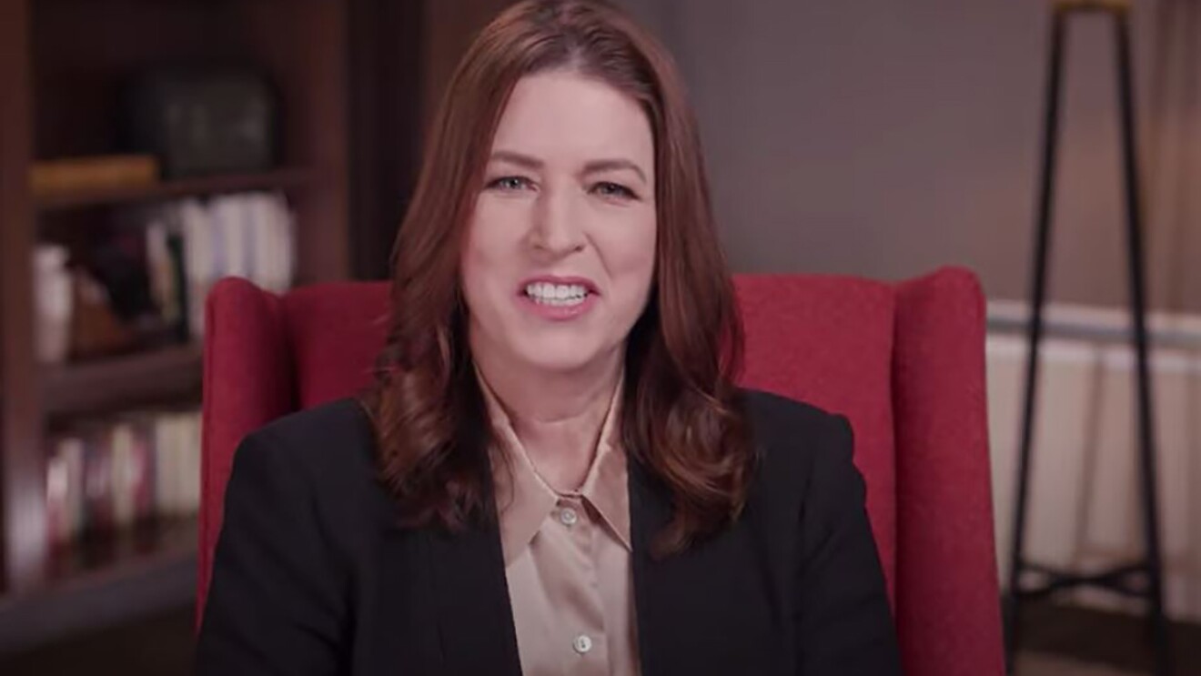 Amazon Sustainability Vice President Kara Hurst sits in an office setting in a red wingback chair. 