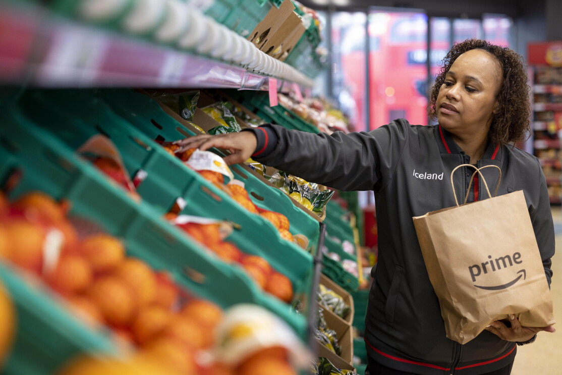 Iceland shop worker packs a bag for delivery on Amazon Prime