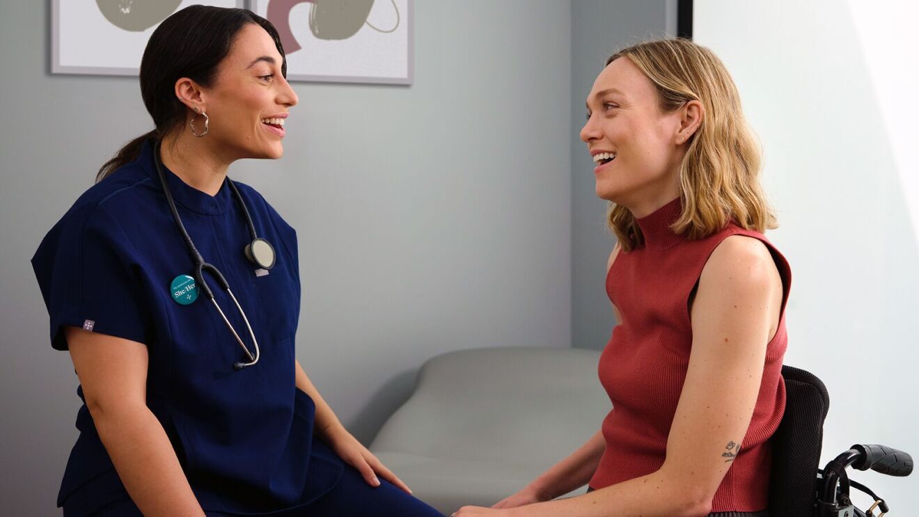 A doctor speaking to a patient in an exam room.