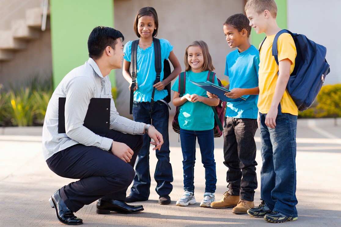 An image of a man talking to a group of young students.