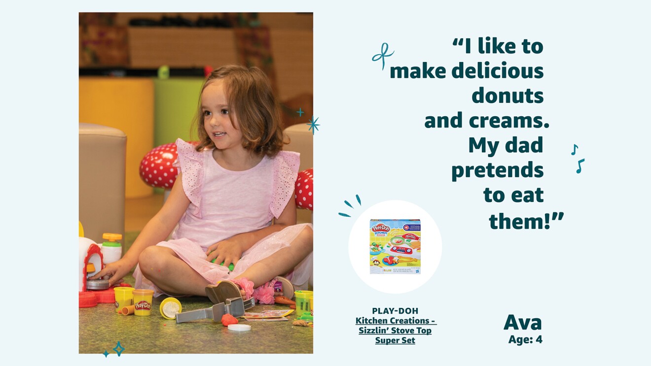 A young girl sits on the floor while playing with a Play-Doh playset