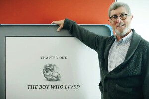 An image of Kindle fan Len Edgerly standing next to a Kindle sign. 