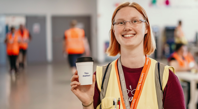 Eine Amazon Mitarbeiter hält einen Kaffeebecher mit de Aufschrift "You matter!"