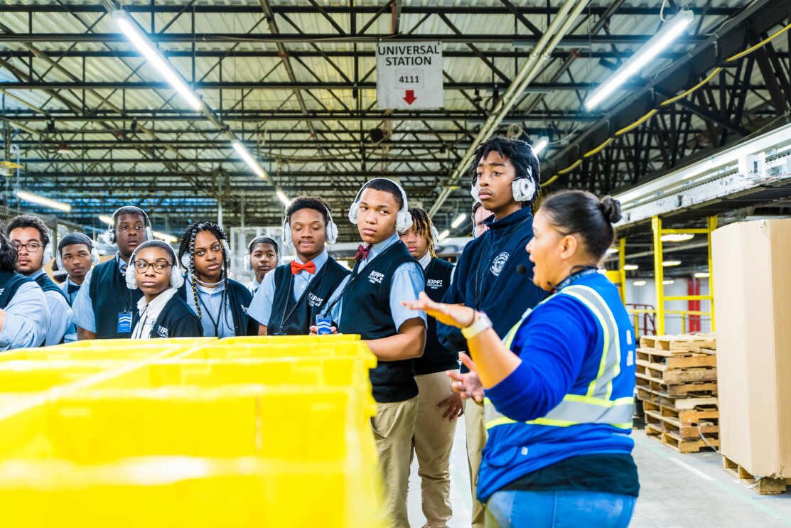 Students attend a tour of an Amazon robotics fulfillment center