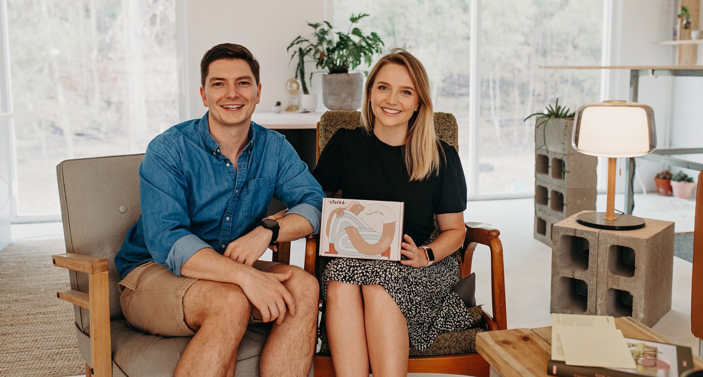 Amazon small business sellers, Ford and Rosa-Clare Willis sit on a sofa with their product in a bright living space