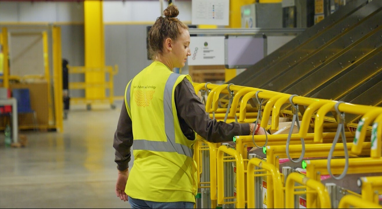 A young woman with a yellow vest is working with a machinery in a FC