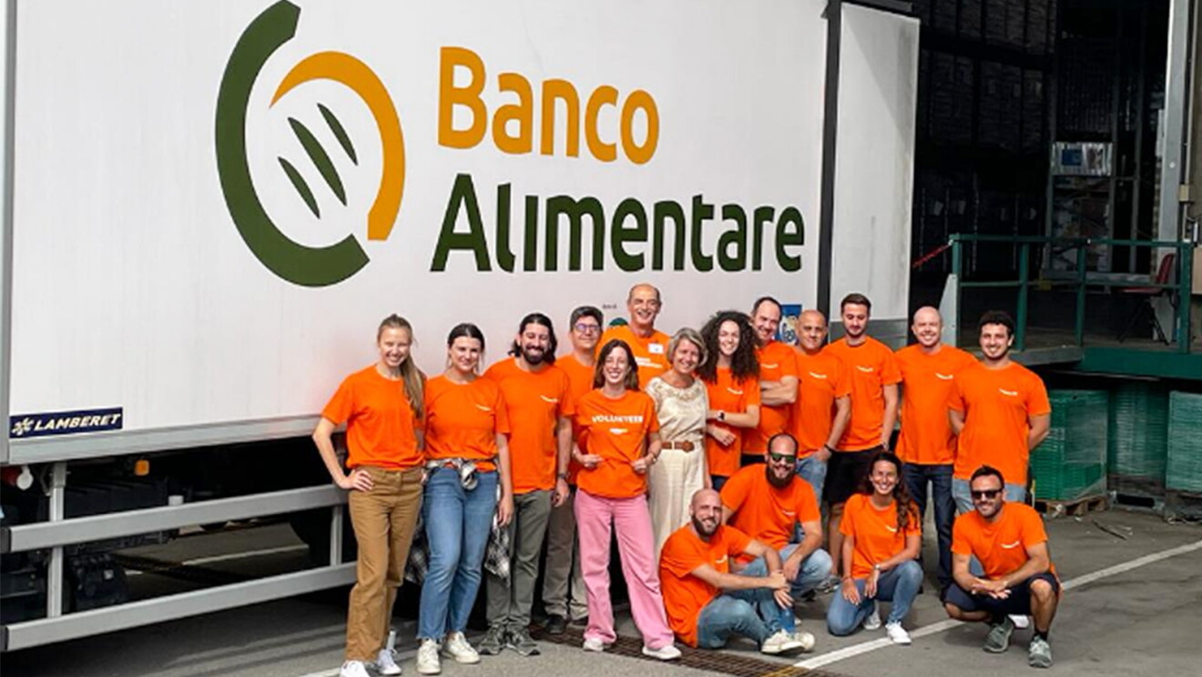 A group of Amazon volunteers wear orange T-shirts.