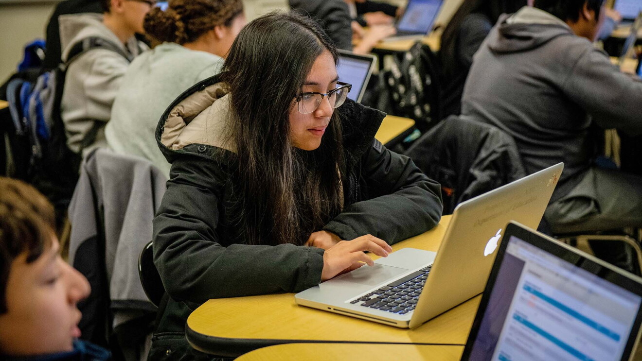 Students work on coding programs on laptop computers in a classroom at a New York City school. 