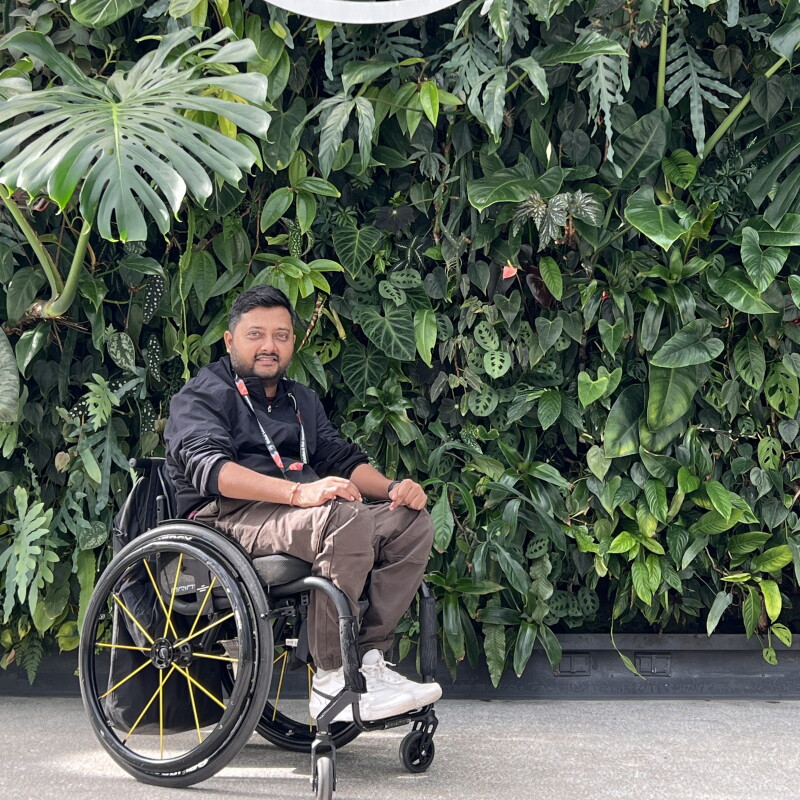 Vaibhav Vadile in front of the Spheres logo and green foliage