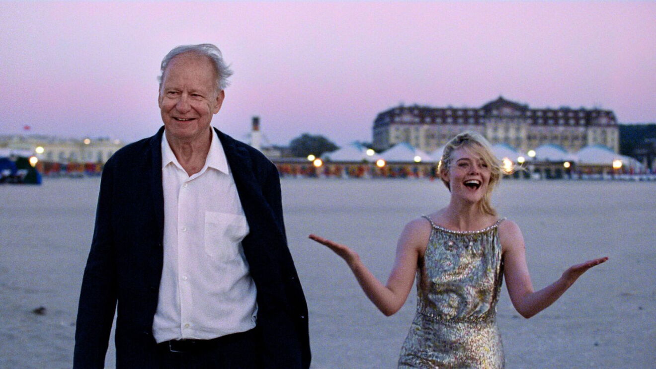 A man and a woman walk on a beach