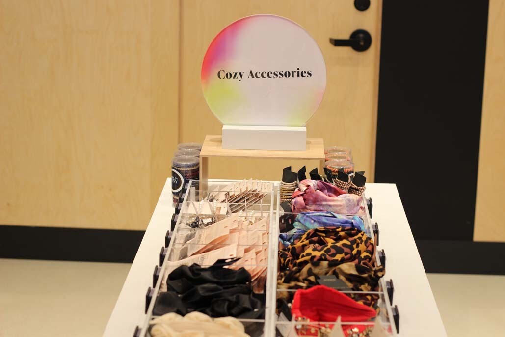 An image of a bin of scrunchies labeled "Cozy Accessories"
