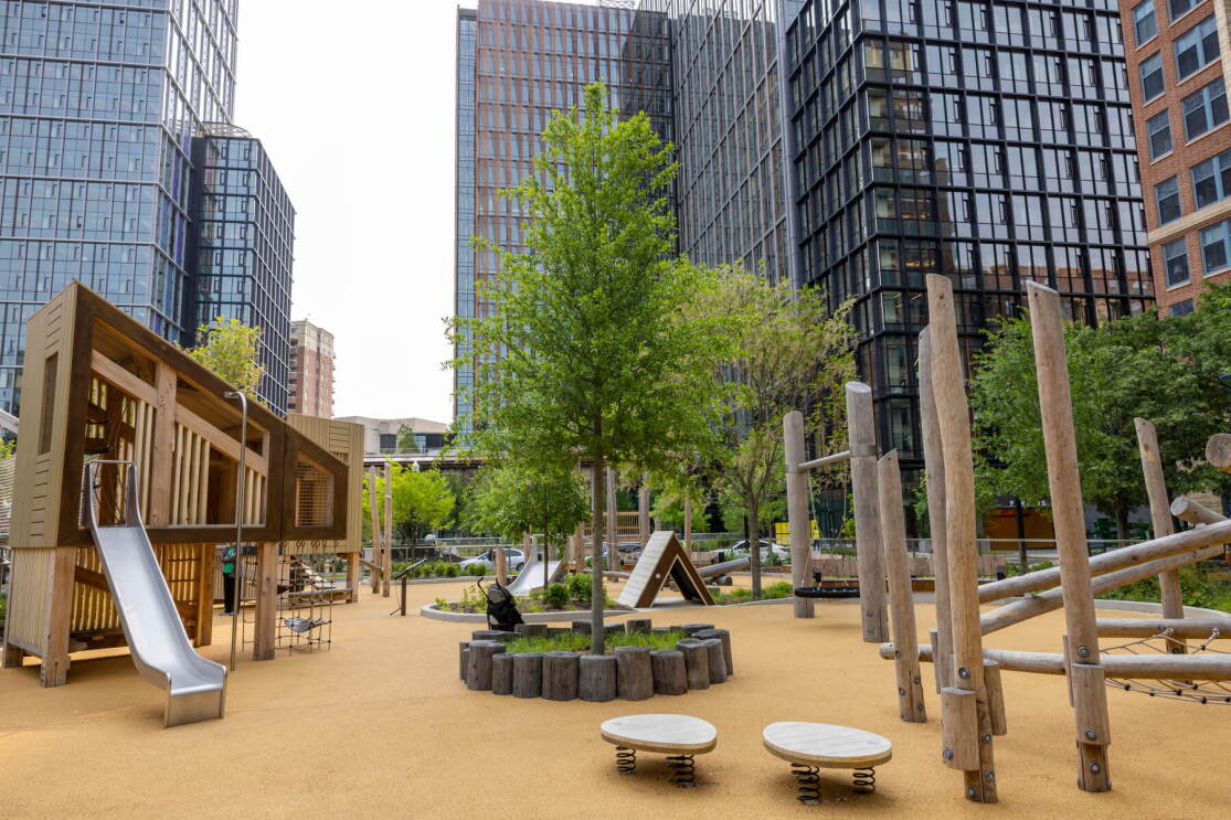 A photo of a children's park that has a slide, treehouse, and other play equipment, located at Metropolitan Park in Arlington, Virginia, next to Amazon HQ2. 