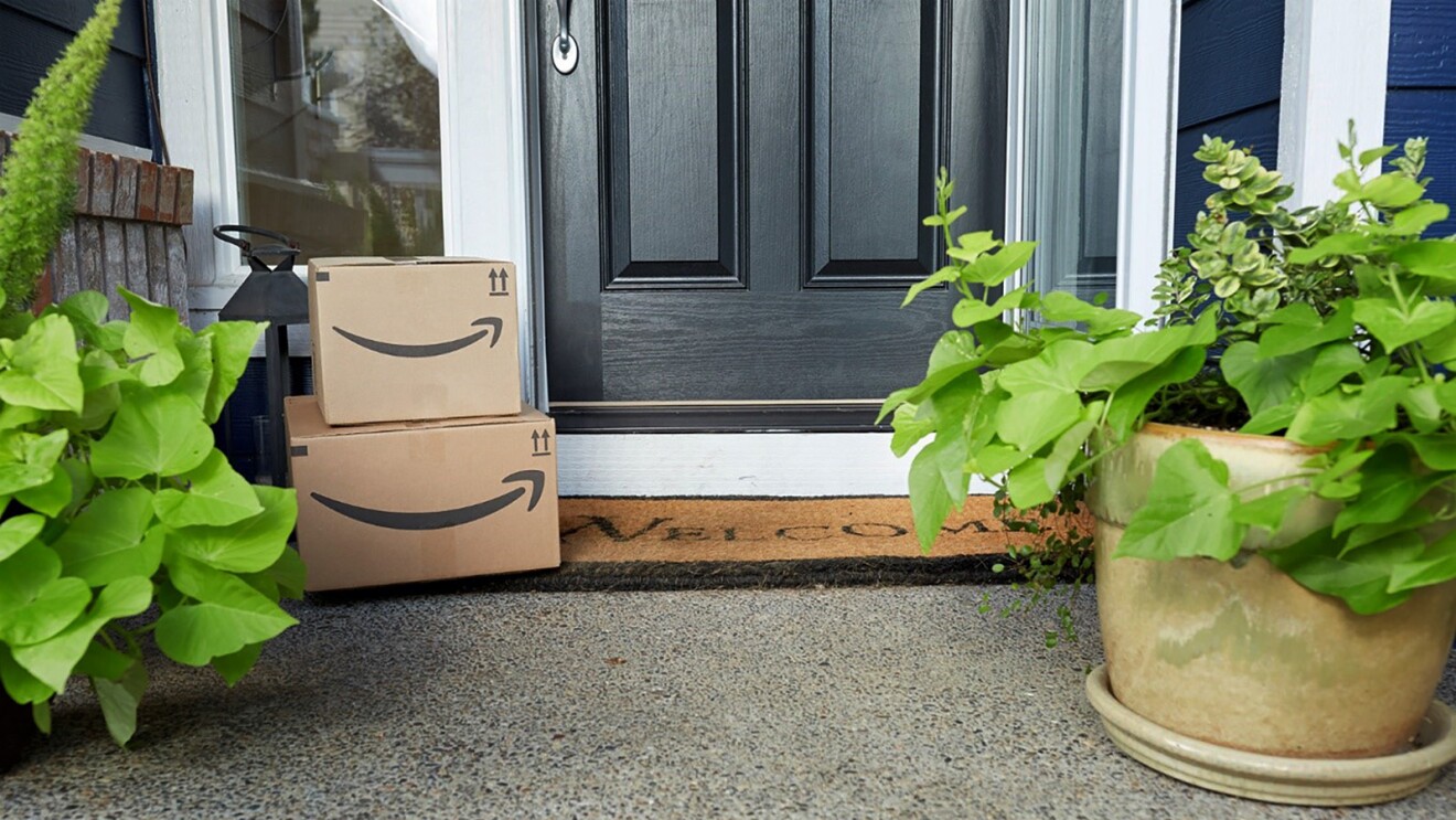 An image of two Amazon packages by the front door of a house. 