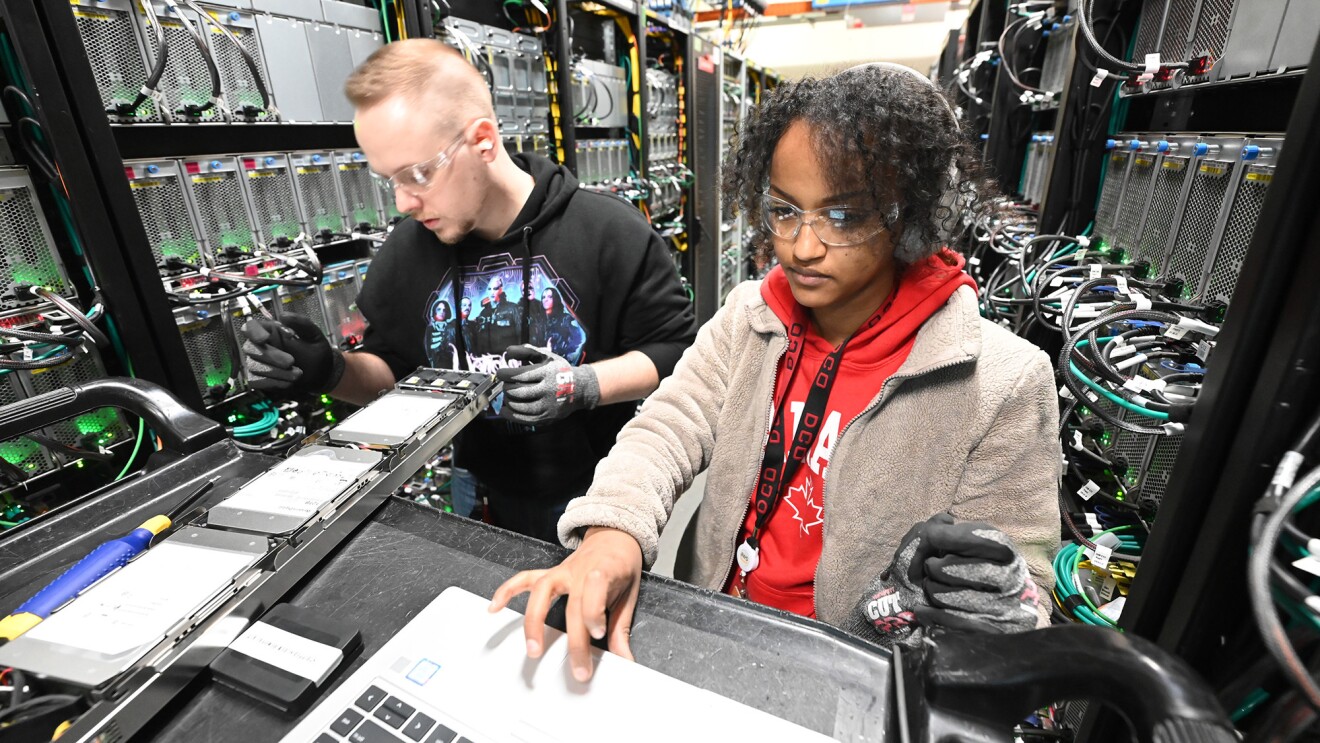 Dos personas trabajando en un centro de datos de AWS.