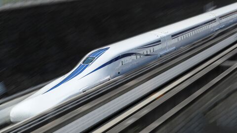 白い車体に青いラインが描かれた流線形の車両が高速で走っている