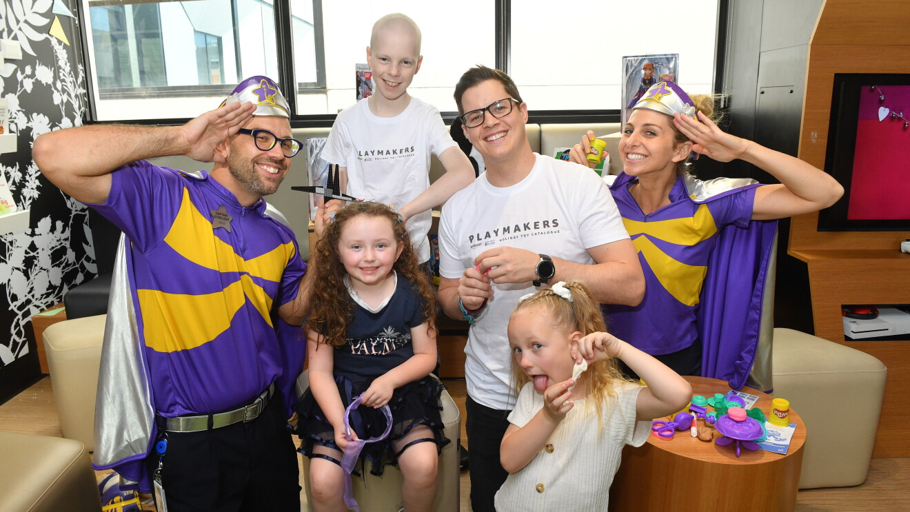 Children smile to the camera in a hospital setting with Starlight Children's Foundation volunteers