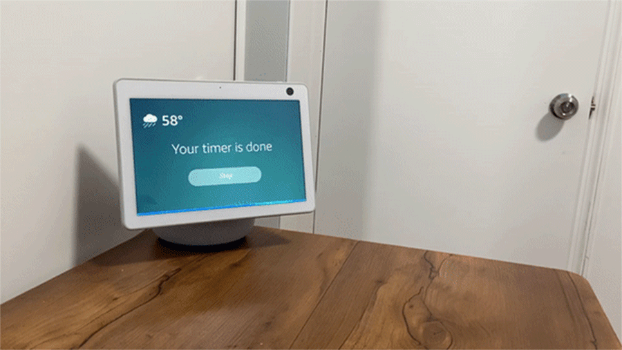 A GIF that shows a hand waving at an Echo Show to dismiss an alarm.