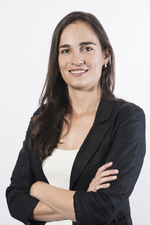 Eugenia. Pelo largo castaño liso, pendientes, sonriendo a la cámara y con los ojos también castaños. 