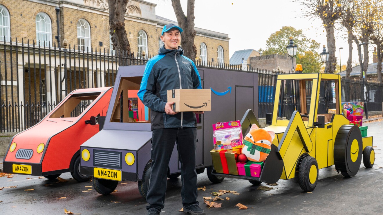 Amazon delivery person with colorful toy vehicles on city street