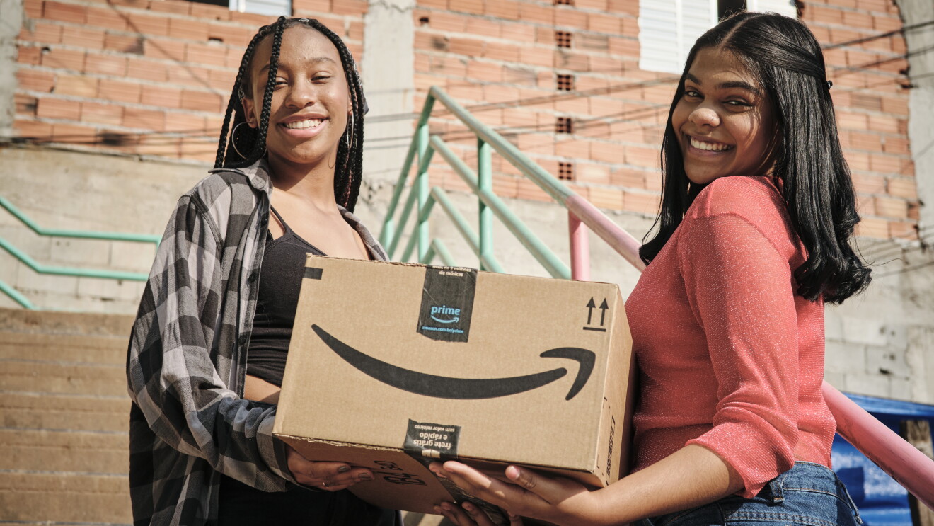 Mulheres seguram caixas da Amazon Prime em Paraisópolis