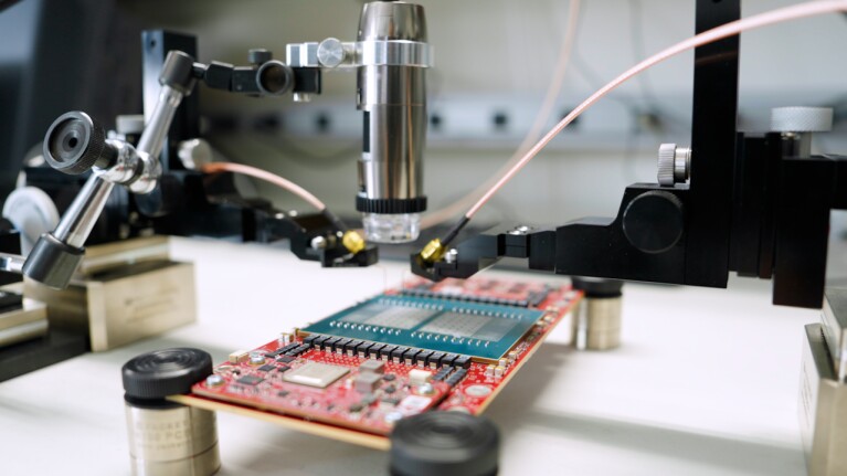 Microscope examining circuit board in electronics lab