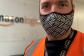 Amazon employee wearing  a mask and orange high vis vest 