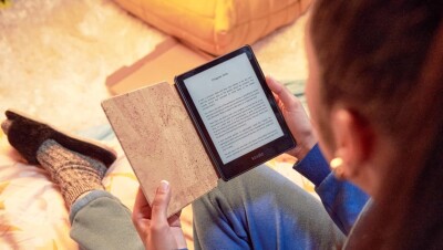 A woman reads an eBook on a Kindle device