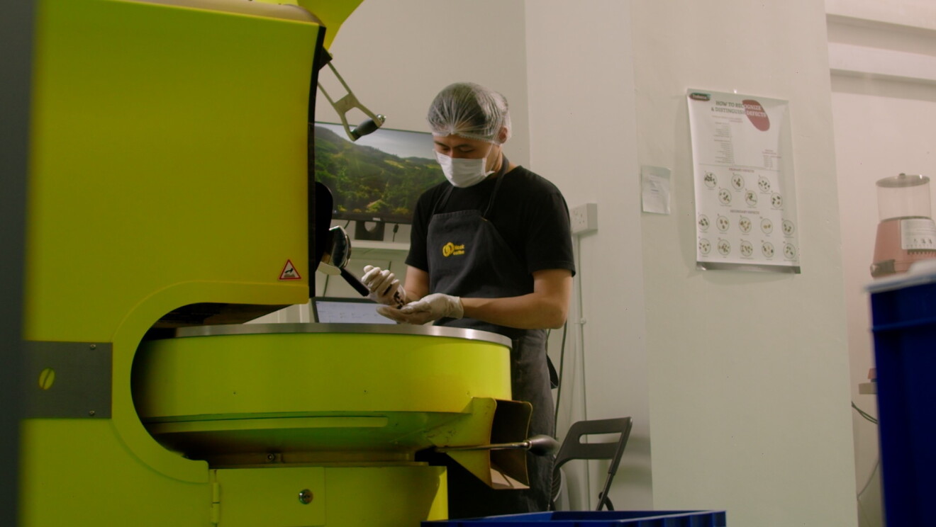 Head of Coffee, Goh Eng Kit, roasting beans at the roastery within Hook Coffee's premises