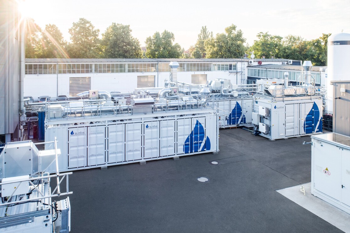 El sistema blanco del especialista en electrólisis de Dresden Sunfire bajo el sol y los árboles al fondo.