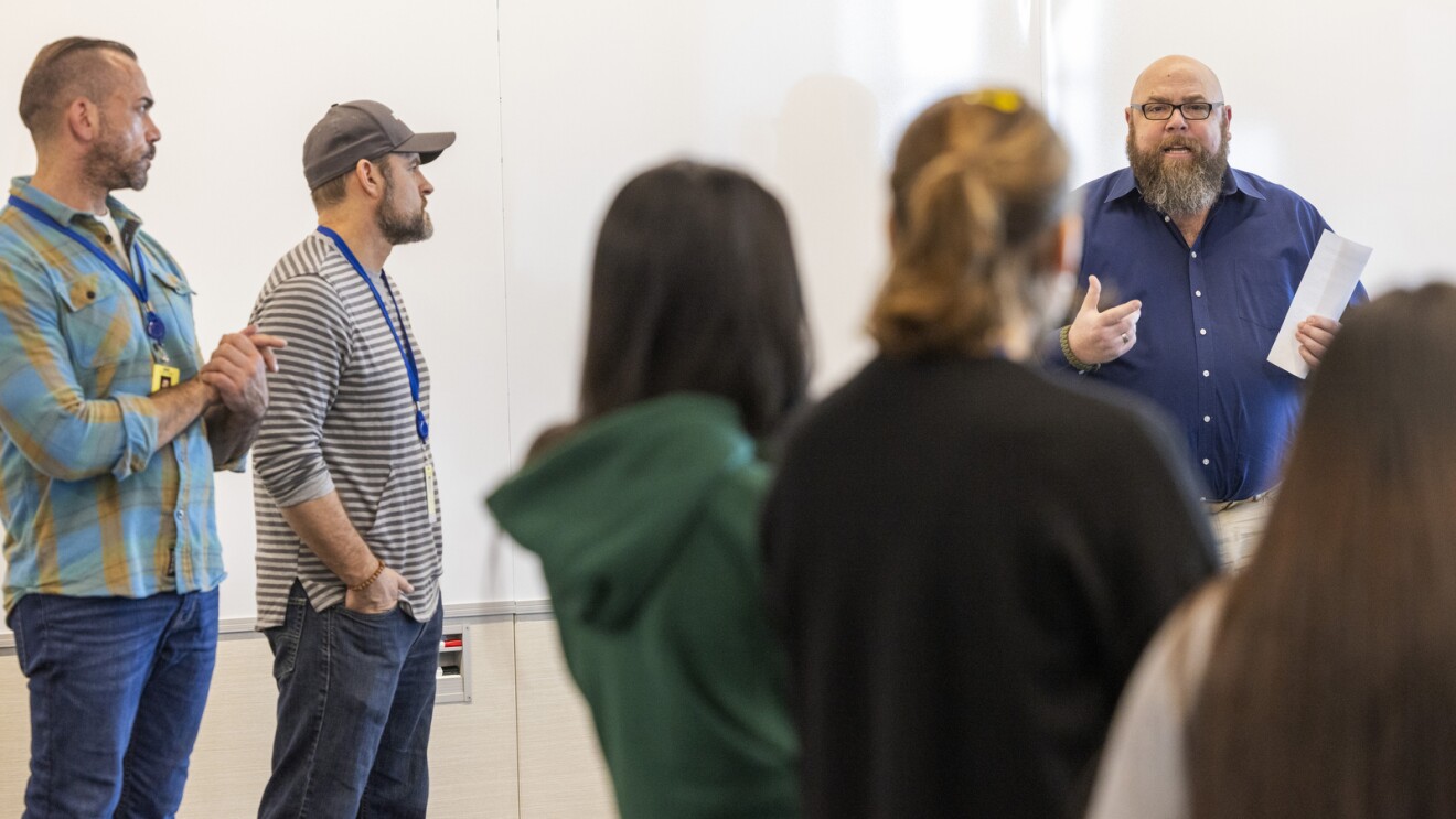 Amazon employees stand in a circle for a meeting.