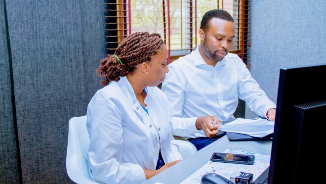 两名医生的照片在办公室伏案工作面前的桌面电脑。