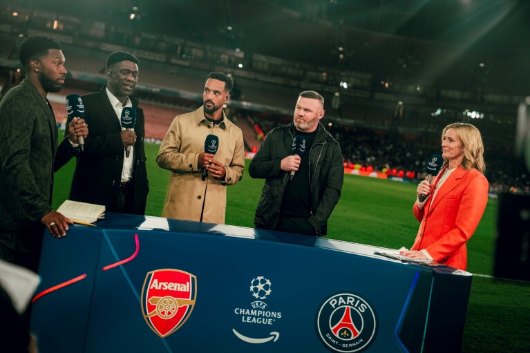 Sports commentators including Wayne Rooney and Gabby Logan at a Champions League match between Arsenal and Paris Saint-Germain