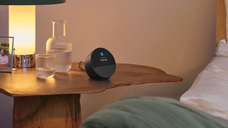 The Amazon Echo Spot on a nightstand with the time displayed.