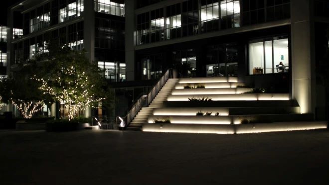 夜に建物の前に光っている階段が置かれている。