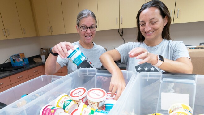 两个女人在分类食物的图片。