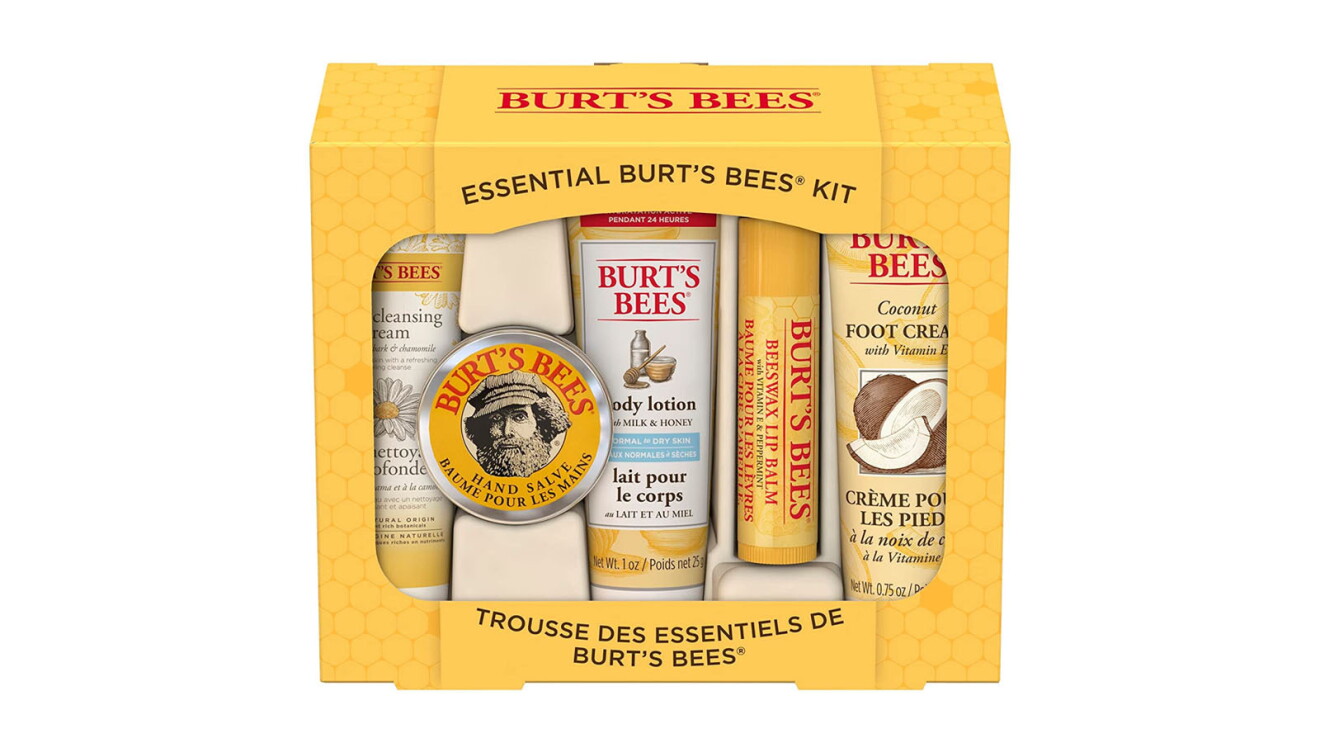 An image of the Burt's Bees stocking stuffer gift set. It comes in a yellow box with the Burt's Bees logo on the front. There is a clear portion in the box that shows its contents, which include travel-size bottles of lip balm, deep cleansing cream, hand salve, and body lotion & coconut foot cream.