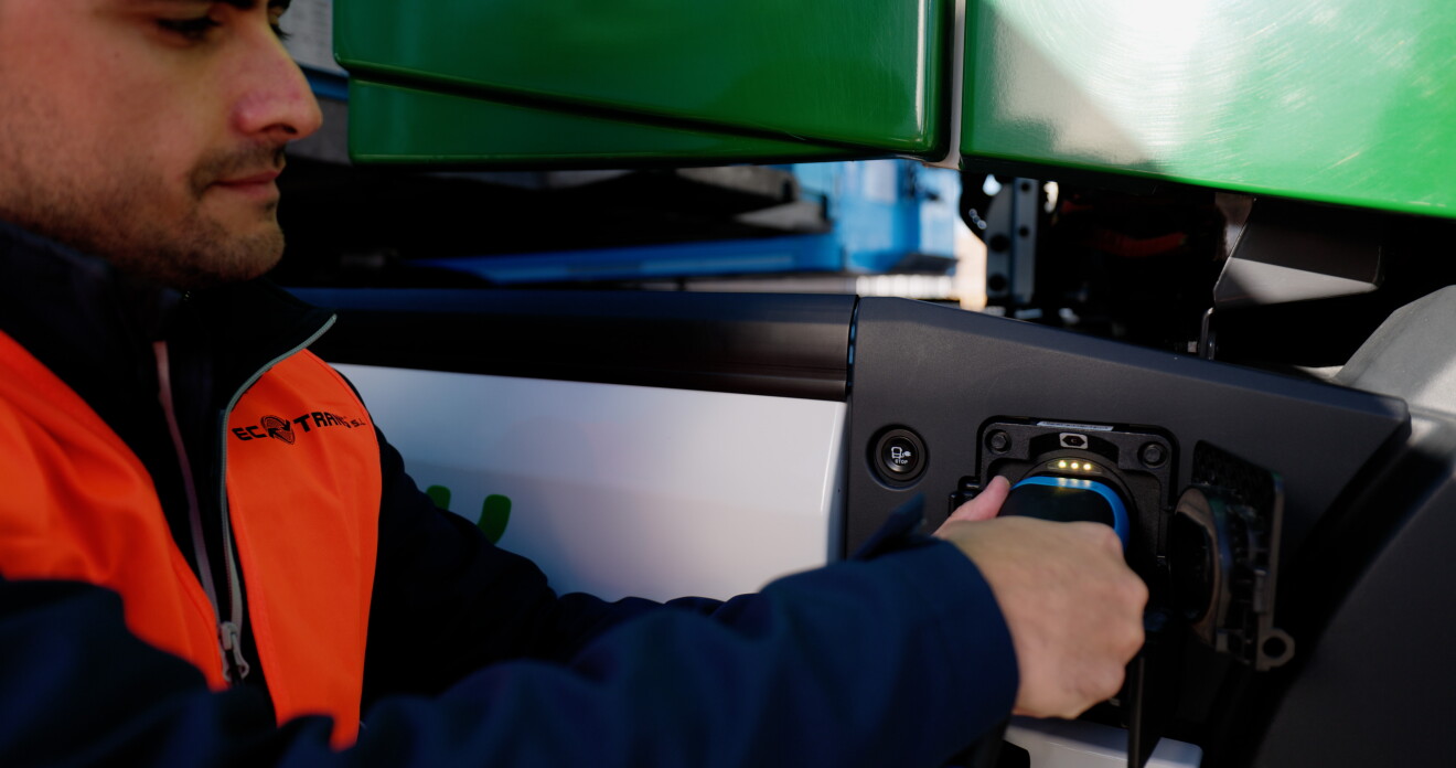 Ecotrans worker plugs in electric truck cable.jpg