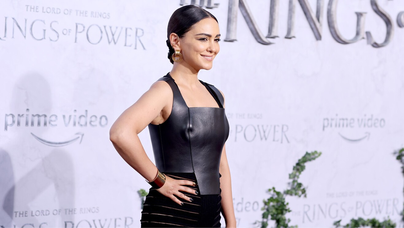 An actress from the Lord of the Rings the Rings of power smiles for a photo on the red carpet of the premiere.