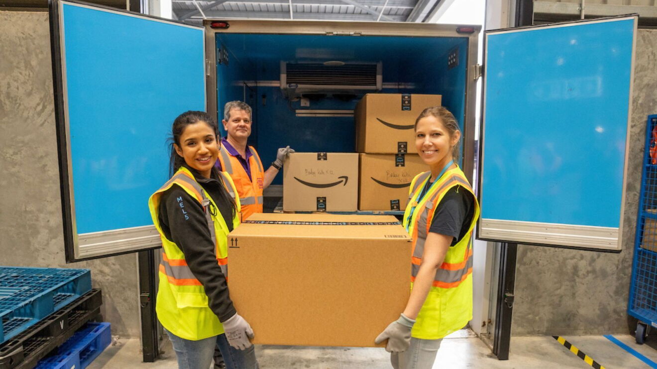 Amazon In The Community Australia lead Charlotte Richardson and another Amazon employee packing relief kits into a van.
