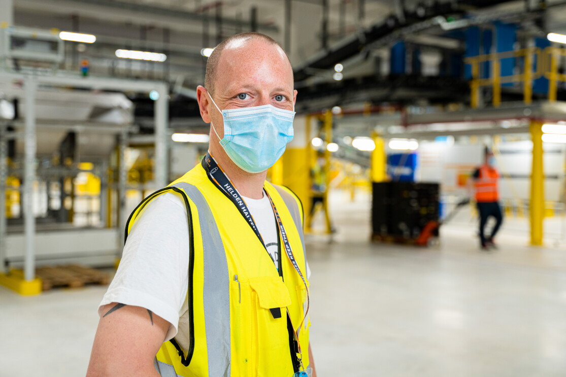 Marcel Flügel mit Maske und Weste im Amazon Logistikzentrum in Oelde
