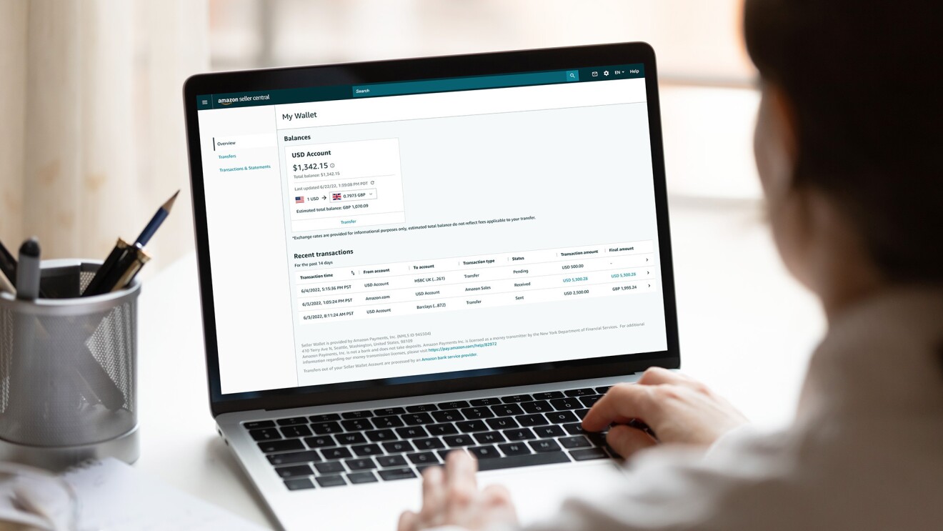 的笔记本电脑坐在桌子上。在屏幕上是一种新的“电子钱包”仪表板亚马逊卖家。