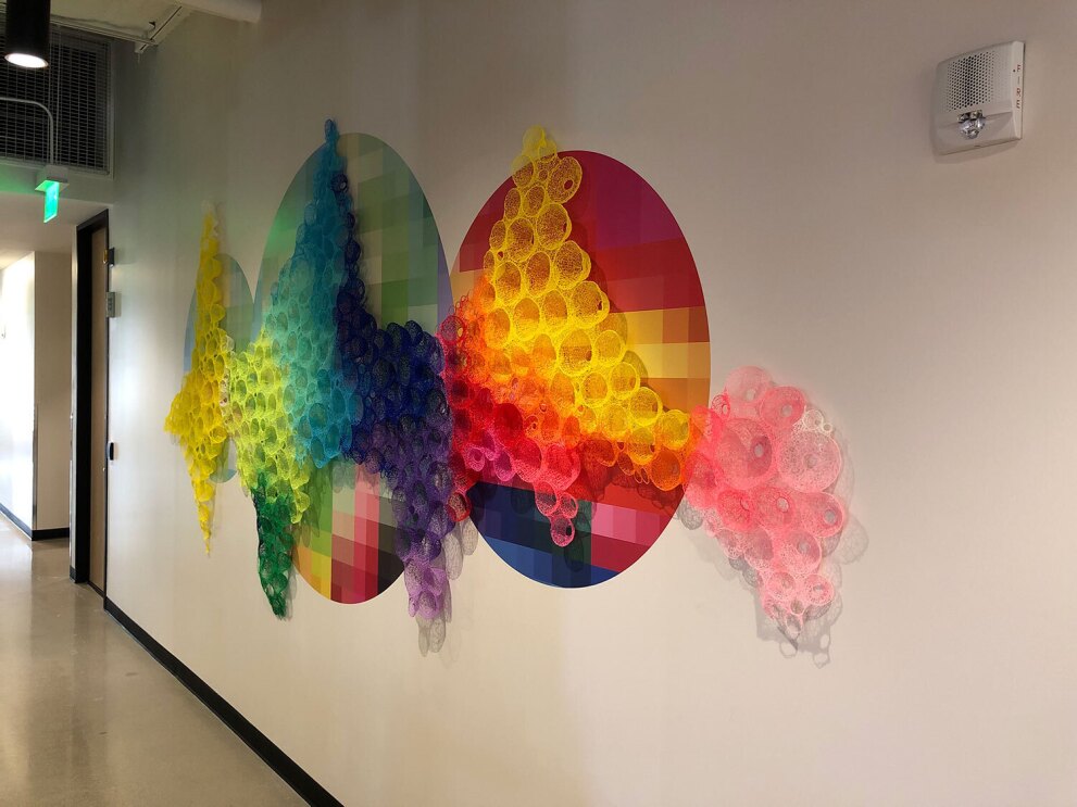 A colorful mural on the wall at the Amazon Denver office. It shows three circles in different colors.