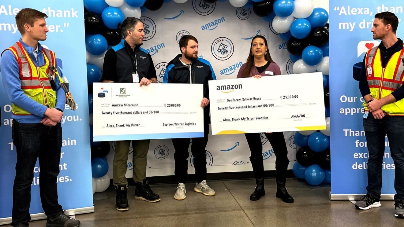 'Alexa, thank my driver' winners hold their winnings in a big check while they stand next to colleagues.